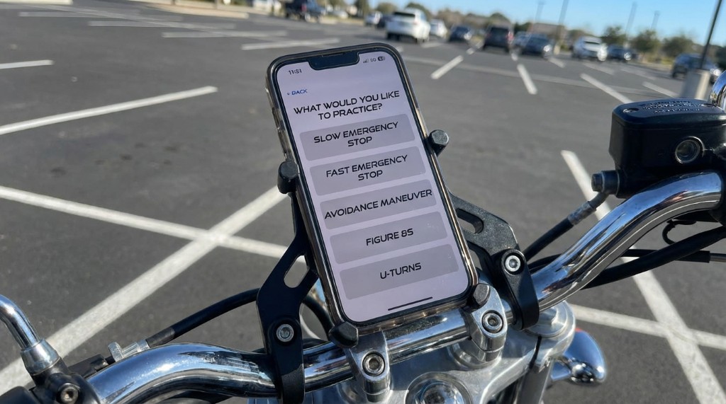 Phone mounted on motorcycle handlebars showing manoeuvre selection screen